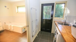 Bathtub, rainfall showerhead, hair dryer, towels