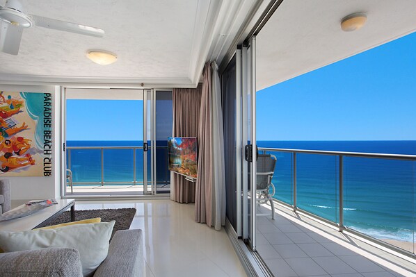 Enjoy the ocean view from the balcony with a sliding glass door, a sofa, and a small table.