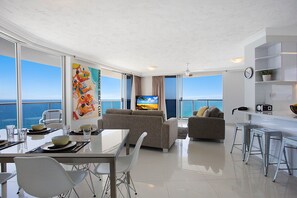 Enjoy ocean views from the spacious living area with a dining table, sofa, and kitchenette.