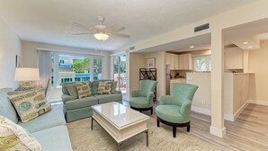 A living room with a sofa, armchairs, a coffee table, and a ceiling fan. - Unit #207 Sand Cay Beach Resort Pool View (Longboat Key)
