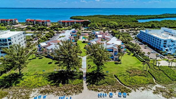 A resort with multiple buildings, a central pool, and a beach area. - Unit #207 Sand Cay Beach Resort Pool View (Longboat Key)