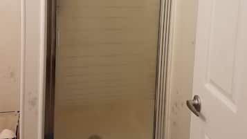 Een bad/douchecombinatie, een haardroger, handdoeken, shampoo