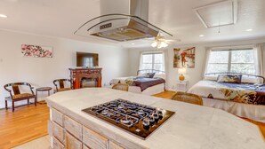 Ein geräumiges Schlafzimmer mit zwei Betten, einem großen Fenster und einer modernen Küchenzeile mit Kochinsel.