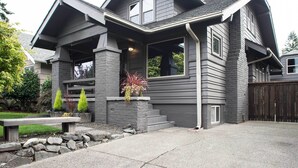 A modern two-story house with a stone foundation, grey siding, and a covered front porch. - Updated Tacoma Home w/ Patio: 3 Mi to Downtown (Tacoma)