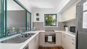 Una cocina moderna equipada con lavavajillas, horno, pileta y refrigerador.
