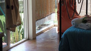 Una habitación con cama, ventana con cortinas y vistas al exterior.