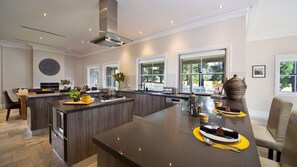A spacious kitchen with a central island, large windows, and a dining area with a view.