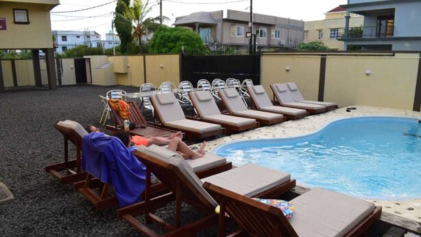 A pool area with multiple lounge chairs and a small pool. - Residence Orchid (Mont Choisy)