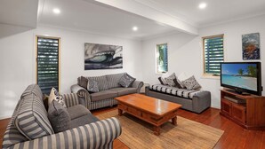 A modern living room with a sofa set, a coffee table, and a TV. - Spacious home with views suitable for 2 families (Point Lookout)