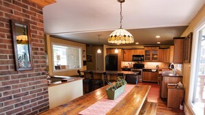Una cocina amplia con armarios de madera, una isla central y una lámpara colgante.