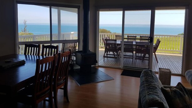 A spacious living area with a large sliding glass door leading to a balcony with a view of the ocean. - Bella Views -  Beach front, WiFi and Foxtel!
Availability School Holidays (Ventnor)
