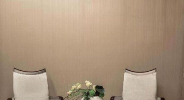 Une table avec deux chaises et un vase de fleurs.