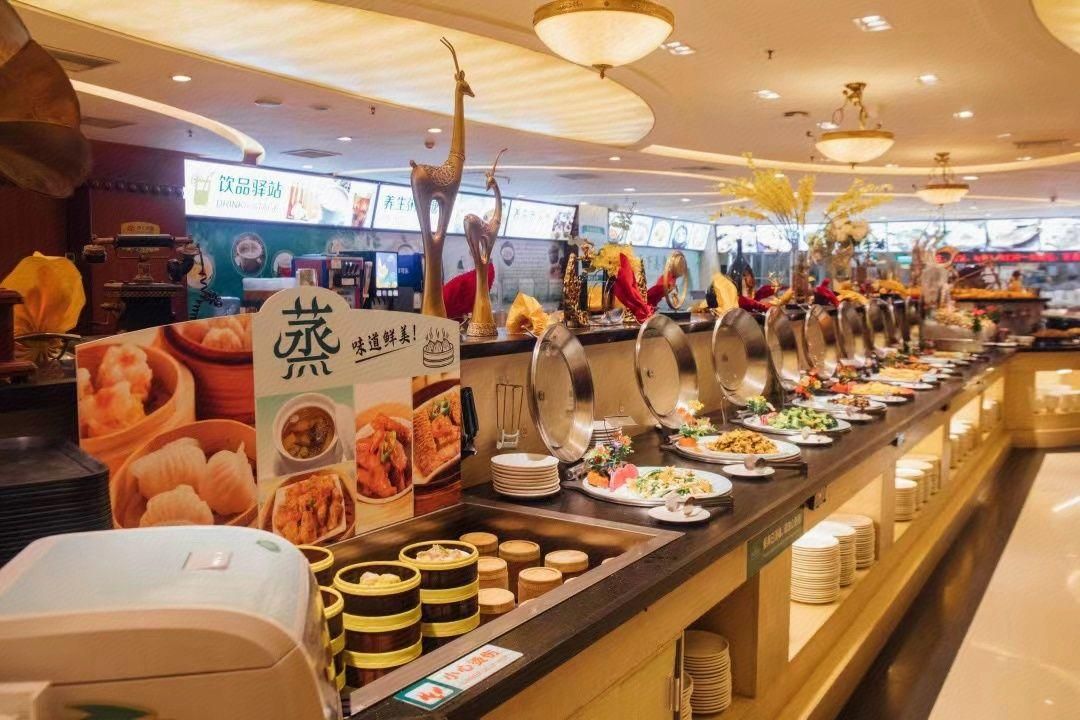 Montaje de bufé con diferentes alimentos y un letrero que indica una opción vegetariana.