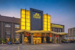 Un hotel con una entrada destacada, grandes ventanales y un cartel que indica que se trata del Hotel Osotto Recreation.