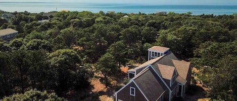 Ein Wohnhaus mit einem zweistöckigen Haus, einer Garage und Blick aufs Meer.