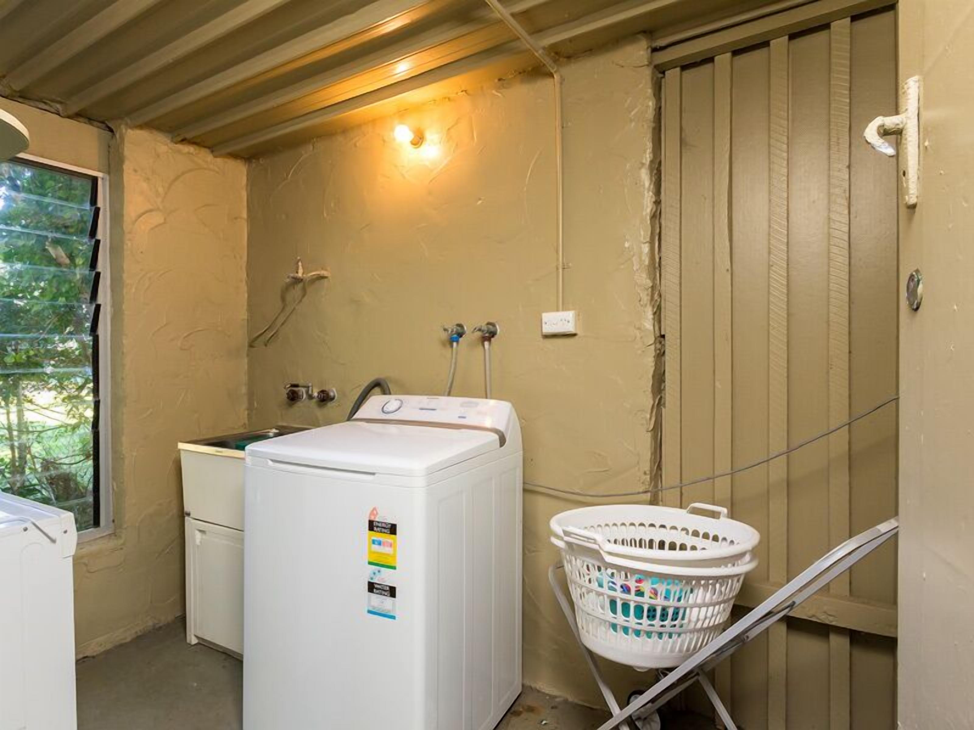 A laundry room with a washing machine, dryer, and a utility sink.