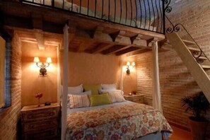 A bedroom with a wooden ceiling, a four-poster bed, two bedside lamps, and a brick wall. - Chic Villa Oasis with Pool, Cook & Maid, Steps to Beach (Bucerias)