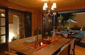 A dining area with a wooden table, chairs, and a chandelier. - Chic Villa Oasis with Pool, Cook & Maid, Steps to Beach (Bucerias)