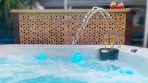 Ein Whirlpool mit Wasserstrahlen und einer Champagnerflasche.