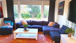 Ein Wohnzimmer mit Ecksofa, Couchtisch und Fernseher auf einem Schrank.