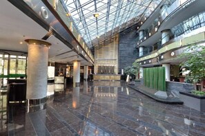 A spacious atrium with a high ceiling, polished marble floors, and a central reception area. - Huangyan International Hotel (Taizhou)
