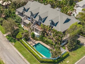 A large, multi-story house with a swimming pool and lush landscaping. - Kendall Beach Apartments 5 - Belongil Beach (Byron Shire)