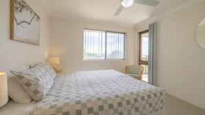 A bedroom with a bed, a chair, a window, and a ceiling fan. - Intrepid, 12/3 Intrepid Close - right on the beachfront (Nelson Bay)