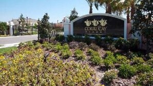 A sign for Coral Cay Resort with a clear view of the entrance and surrounding greenery. - Close to Disney, Seaworld, 4BR Townhouse with Hot Tub (Kissimmee)