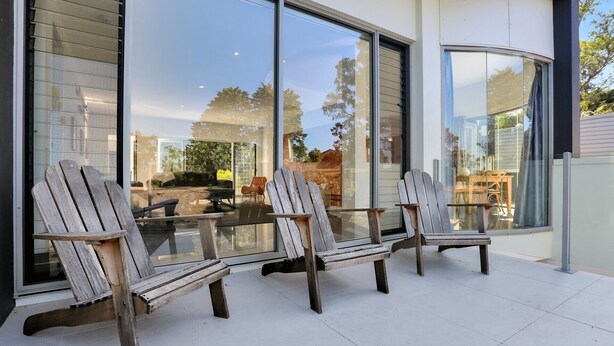 A patio with three wooden Adirondack chairs and a glass table. - The White House - Merimbula (Merimbula)