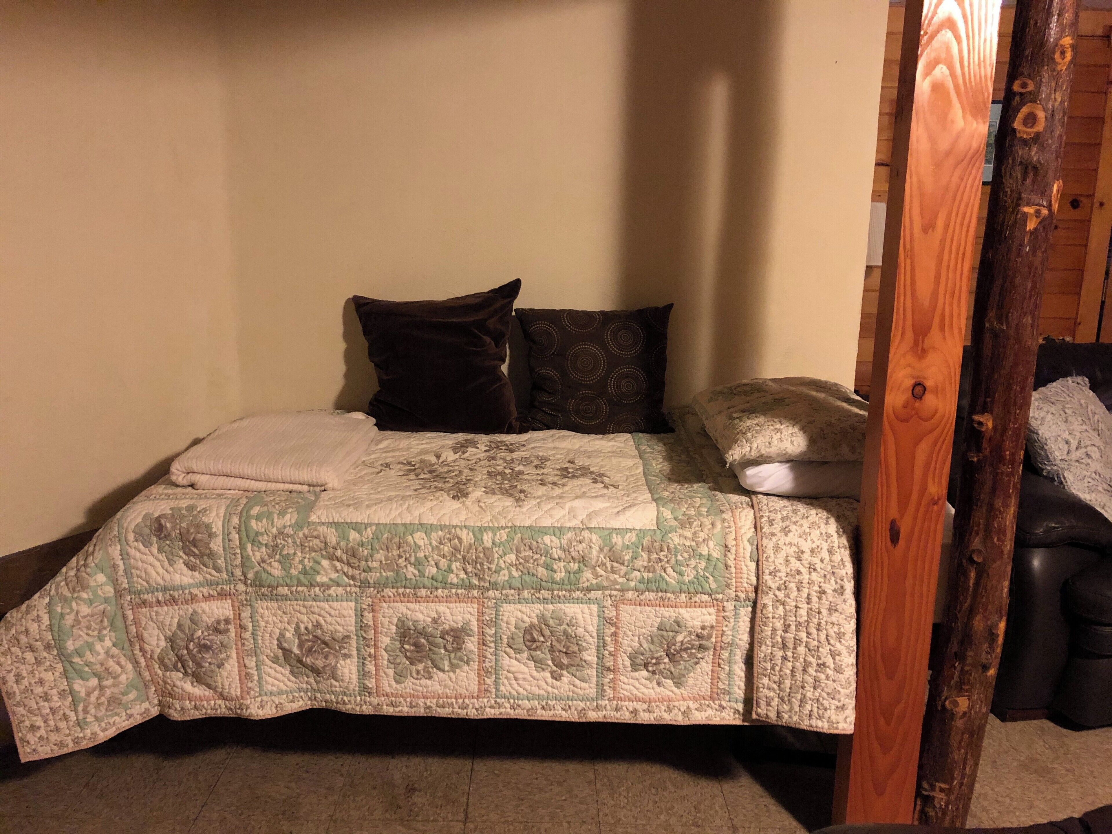 Une chambre à coucher avec un lit, des oreillers et une tête de lit en bois.