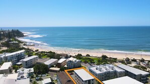 Zona residencial costera con propiedades frente al mar, una playa y una vista despejada del océano.