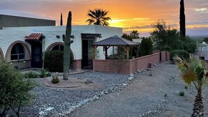 Un edificio in stile desertico con finestre ad arco, un patio e un gazebo.