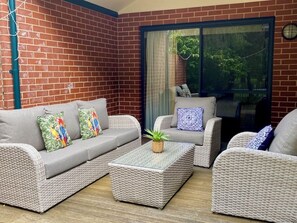 A cozy outdoor seating area with wicker furniture, a cushioned sofa, and a coffee table. - Salt & Peppies - across from beach, wi-fi (Dunsborough)