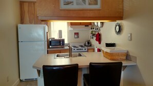 Une cuisine compacte équipée d’un réfrigérateur, d’un four à micro-ondes, d’une cuisinière et d’un évier.