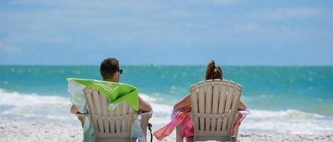 Una playa cerca, sillas reclinables de playa, toallas de playa