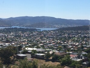 A residential area with houses, a lake, and hills in the background.