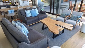 Una sala de estar moderna con un sofá, sillones, una mesa de centro y una zona de comedor.