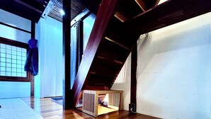A room with wooden flooring, a sloped ceiling, and a small wooden crib. - 5 Min from Seoul Station! Authentic meets Modern & Cozy Retreat (Seoul)