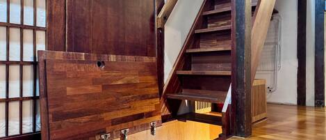 Una escalera de madera con una puerta de madera y una ventana de diseño cuadriculado.