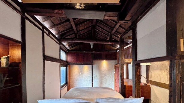 A traditional Japanese-style room with tatami flooring, a low wooden ceiling, and a bed with white bedding. - 5 Min from Seoul Station! Authentic meets Modern & Cozy Retreat (Seoul)
