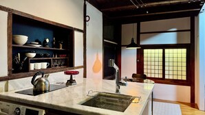 A kitchen with a marble countertop, stainless steel kettle, and a built-in washing machine. - 5 Min from Seoul Station! Authentic meets Modern & Cozy Retreat (Seoul)