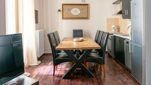 Une cuisine de taille réduite comprenant une table à manger, des chaises et un réfrigérateur.