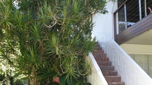 Eine Treppe führt zu einem weißen Gebäude mit einem Schild, auf dem 'Ray White' steht.