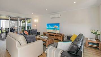 Televisión de pantalla plana, reproductor de DVD, libros y videoteca