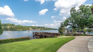 A lakeside property with a grassy lawn, a dock, and a view of the lake. - Your PRIVATE Hot Springs Lake Hamilton Vacation Paradise  (Royal)