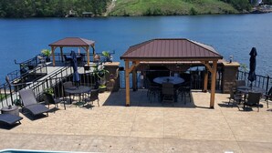 A pool area with a gazebo, lounge chairs, and a view of a lake. - Your PRIVATE Hot Springs Lake Hamilton Vacation Paradise  (Royal)