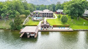 A lakeside property with a dock, a pool, and a large house with multiple decks and outdoor seating. - Your PRIVATE Hot Springs Lake Hamilton Vacation Paradise (Royal)