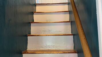 Un escalier avec des marches blanches et une rampe en bois.