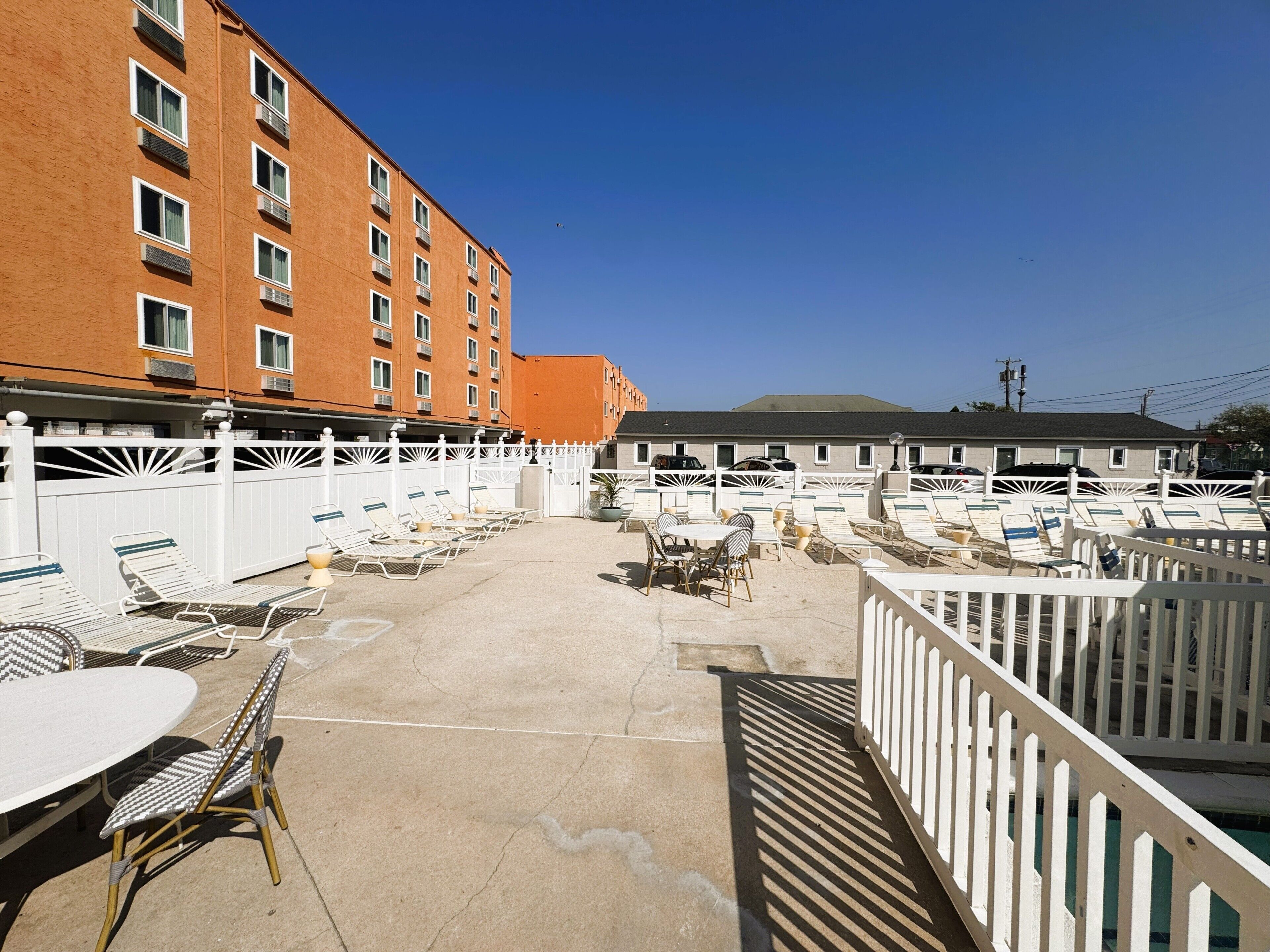 A hotel courtyard with outdoor seating, a pool, and a building with multiple windows.