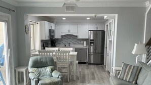 A modern kitchen with white cabinets, a stainless steel refrigerator, and a ceiling fan. - Three Bedroom Beachfront Condo at Pinnacle Port  (Panama City Beach)